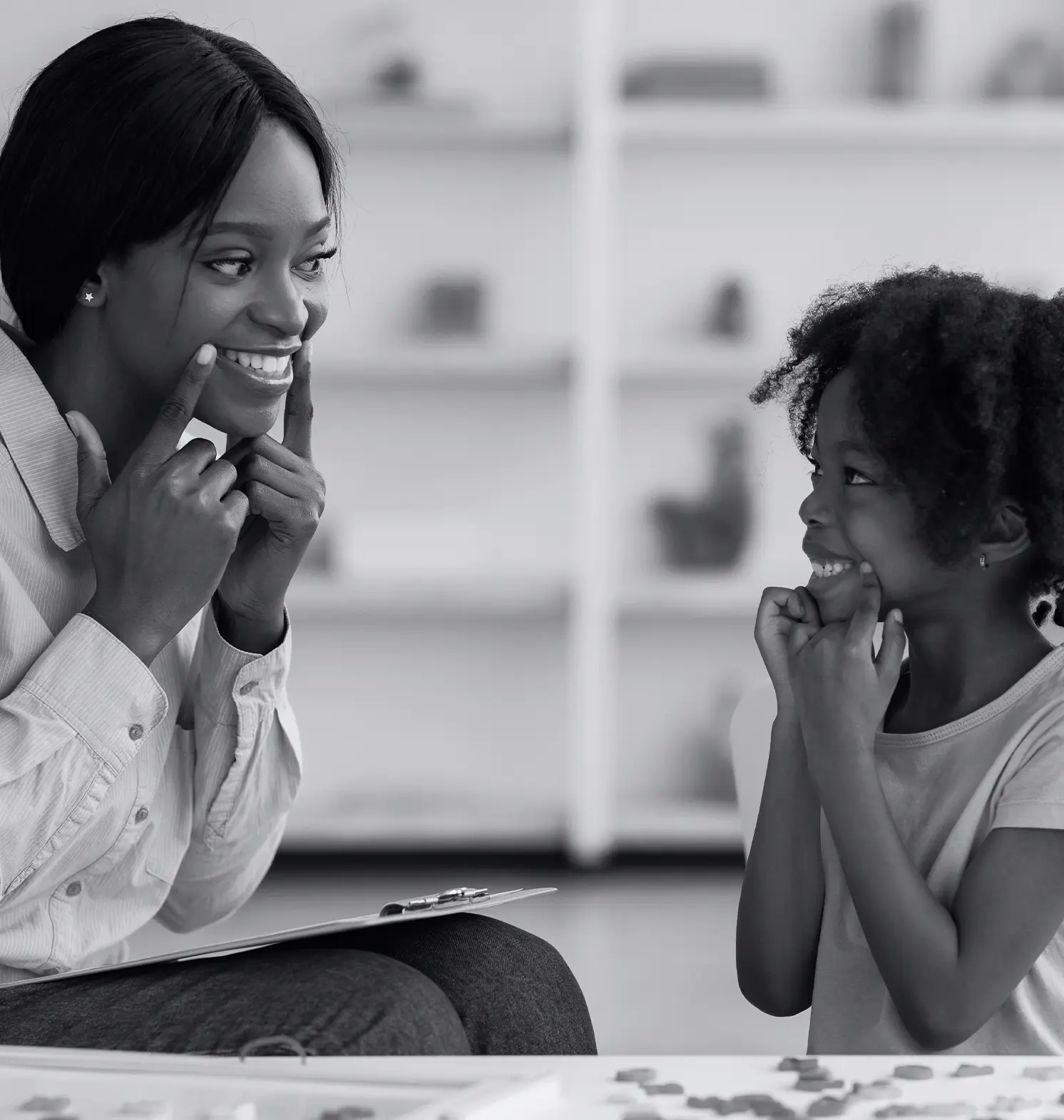 Speech therapist working with little girl at clinic